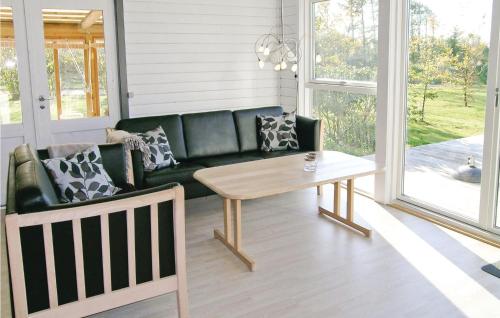 a living room with a green couch and a table at Holiday Home Skovly Roslev Vi in Glyngøre