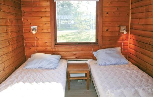 two beds in a room with a table and a window at Amazing Home In Roslev With 4 Bedrooms in Glyngøre