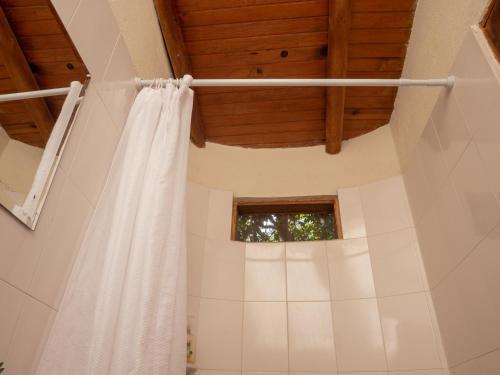 a bathroom with a white shower curtain and a window at Kallpa B&B in Palomino