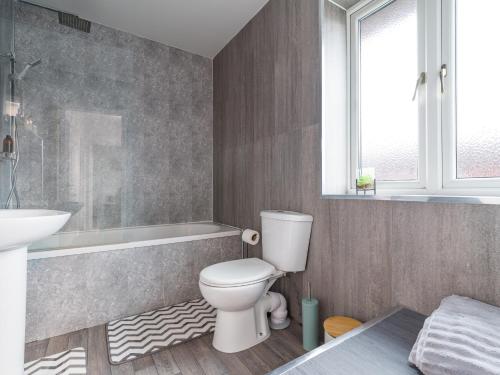 a bathroom with a toilet and a sink and a tub at Beautiful Durham accommodation - Perfect for contractors in Shincliffe