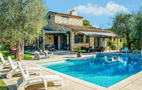 a swimming pool with chairs and a house at 3 Bedroom Gorgeous Home In Grasse in Grasse
