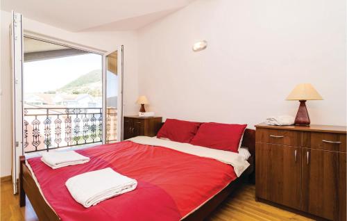 a bedroom with a red bed and a balcony at Awesome Apartment In Baosici With 3 Bedrooms And Wifi in Herceg-Novi