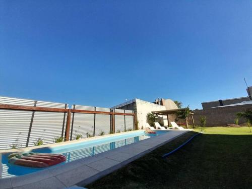 a swimming pool with two life rafts next to a building at Casa Quinta FP en Rio Cuarto in Río Cuarto