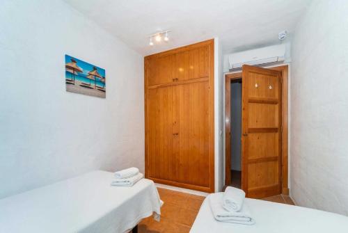 una camera con due letti e una porta in legno di Bini Carmen a Binibeca