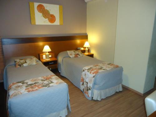 a hotel room with two beds and two night stands at Hotel Serra Nevada in Canela