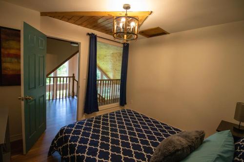 um quarto com uma cama, uma janela e um lustre em Paradise Palace Waterfront Cottage hottub 7bedroom with hottub em Bobcaygeon