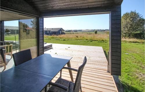a patio with a table and chairs on a deck at Cozy Home In Samsø With Sauna in Nordby