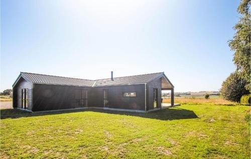 a black house in a field with a grassy yard at Cozy Home In Samsø With Sauna in Nordby