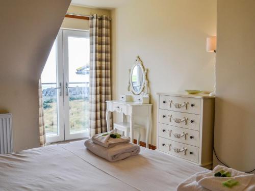 a bedroom with a bed with a dresser and a mirror at The Greenkeeper - Uk39823 in Portpatrick
