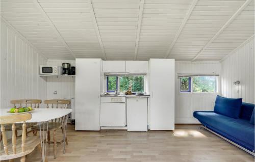 a kitchen and dining room with a blue couch and a table at 1 Bedroom Nice Home In Hampen in Hampen