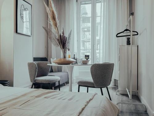 een slaapkamer met een tafel en stoelen en een bed bij Suite Opium in Lyon