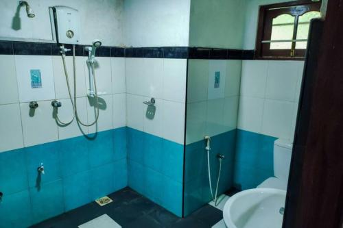 ein Bad mit einer Dusche, einem WC und einem Waschbecken in der Unterkunft Pleasant Villa in Weligama in Weligama