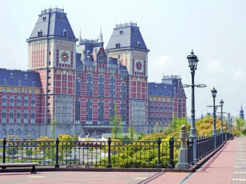 a large red building with two towers with clocks at Hotel Okura JR Huis Ten Bosch in Sasebo