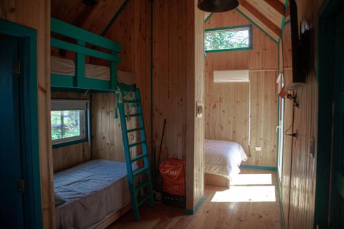 a room with two bunk beds and a ladder at Tiny Fuy in Puerto Fuy