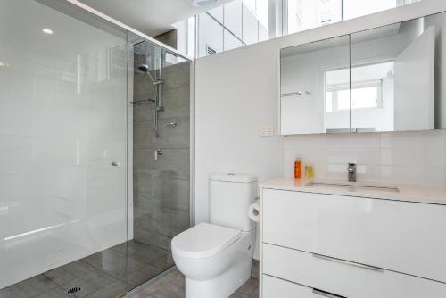 a white bathroom with a toilet and a shower at Two bedroom apartment on Ann Street Fortitude Valley By Serain Residences in Brisbane