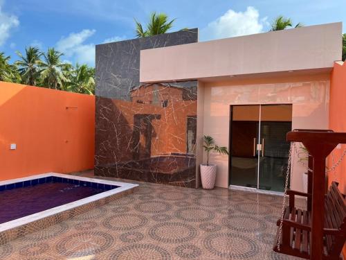 Casa con suelo de baldosa y paredes de color naranja en MaragogiMeuCaribe, en Maragogi