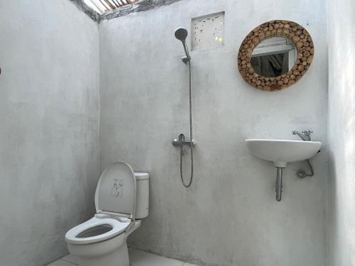 a bathroom with a toilet and a sink at La Royale Nusa Penida in Toyapakeh