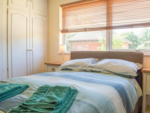 a bedroom with a bed with two towels on it at Love Lane Bungalow in Bridgnorth