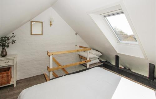 a attic bedroom with a bed and a window at Cozy Apartment In Sams With House Sea View in Ballen