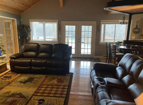 a living room with a leather couch and a table at Lakehouse with Hot Tub close to Ark Encounter in Corinth
