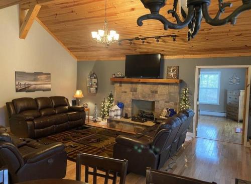 a living room with leather furniture and a fireplace at Lakehouse with Hot Tub close to Ark Encounter in Corinth