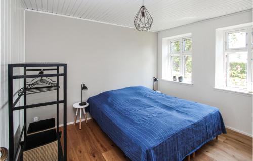 a bedroom with a blue bed in a room with windows at Beautiful Home In Sams With Wifi in Ballen