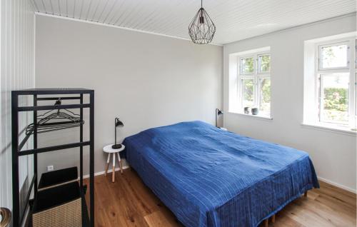 a bedroom with a blue bed in a room with windows at Stunning Home In Samsø With Wifi in Ballen