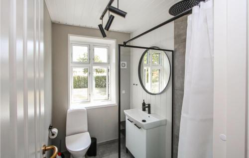 a white bathroom with a sink and a mirror at Beautiful Home In Sams With Wifi in Ballen