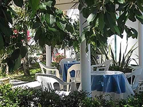 eine Reihe von Tischen und weißen Stühlen mit blauem Tischtuch in der Unterkunft Villa Orchidea in Sorrent