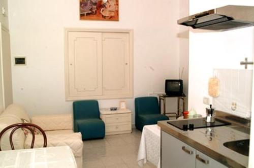 eine Küche und ein Wohnzimmer mit 2 Stühlen und einem Sofa in der Unterkunft Villa Orchidea in Sorrent
