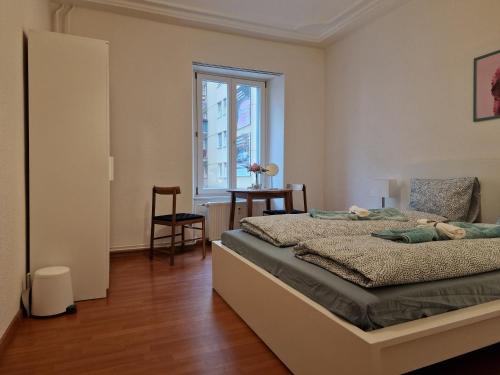 a bedroom with a bed and a table and a window at Bastis City Rooms in Lucerne