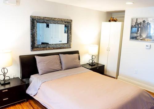 1 dormitorio con 1 cama con espejo en la pared en Luxury Beverly Hills Apartment, en Los Ángeles