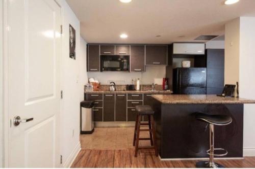 uma cozinha com armários pretos e um balcão e banco em Luxury Beverly Hills Apartment em Los Angeles