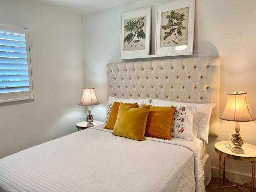 een slaapkamer met een groot wit bed met gele kussens bij Villa Mango in Naples