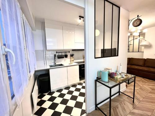 a kitchen and a living room with a checkered floor at COTON Industriel Proche Gare et Centre in Melun