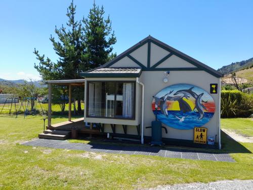 a smallshed with a painting on the side of it at Picton's Waikawa Bay Holiday Park in Picton