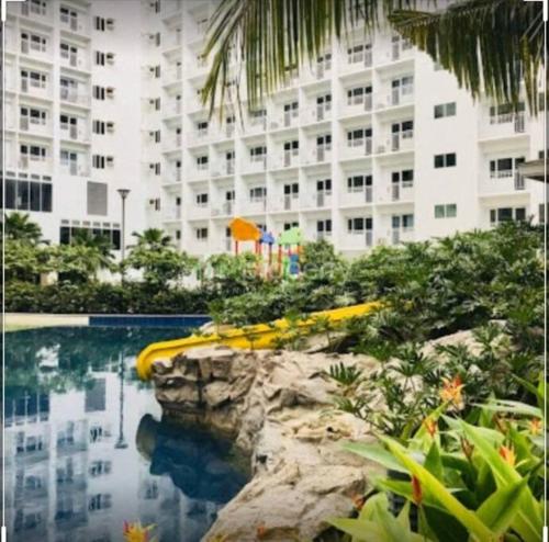 einem Pool vor einem großen Gebäude in der Unterkunft Katei elegantly designed 1-bedroom facing amenity in Manila