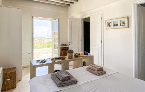 a bedroom with a bed and a bathroom with a window at Stunning Home In Sifnos With House Sea View in Sifnos