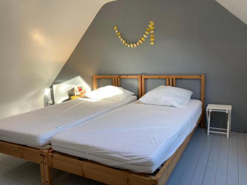 sypialnia z dwoma łóżkami z białymi prześcieradłami i lampą w obiekcie Charmante Maison avec Jardin, Terrasse et Parking - Animaux Acceptés - FR-1-418-196 w mieście Le Palais