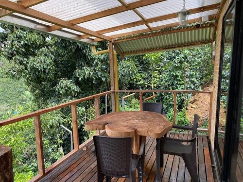 a wooden table and chairs on a deck with a pergola at Meraki Cabaña Privada in Pereira