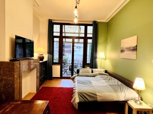 een slaapkamer met een bed en een groot raam bij Cozy, comfortable apt, well located - EU ULB VUB in Brussel