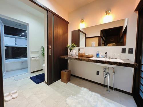 a bathroom with a sink and a large mirror at Japanese style hotel Morigen in Kyotango