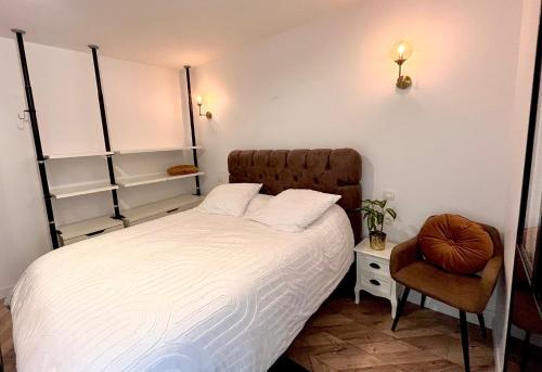 a bedroom with a large bed and a chair at COTON Industriel Proche Gare et Centre in Melun