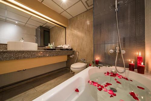 a bathroom with a bath tub with red flowers on it at Mountain Beach Resort & Convention Center in Pattaya South