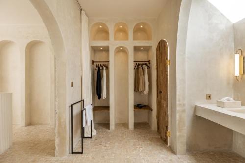 einen begehbaren Kleiderschrank mit einem Waschbecken und einem Spiegel in der Unterkunft Luxe & Unique honeymoon Bocami Suites- 2 by OriVista in Kerobokan