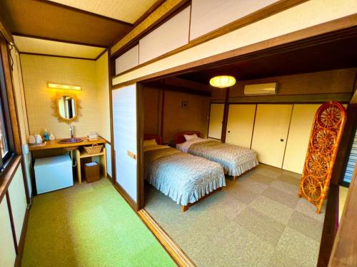 a small room with two beds and a mirror at Japanese style hotel Morigen in Kyotango