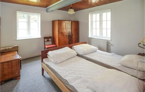 Toftebjerg的住宿－2 Bedroom Awesome Home In Sams，一间卧室配有一张床、一张书桌和两个窗户。