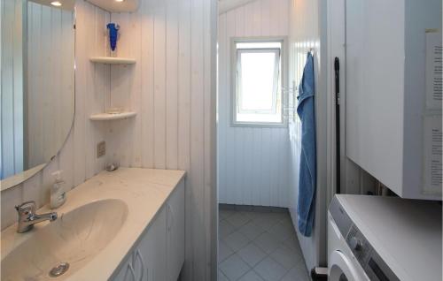 Amazing Home In Sams With House Sea View في Onsbjerg: حمام أبيض مع حوض ومرآة