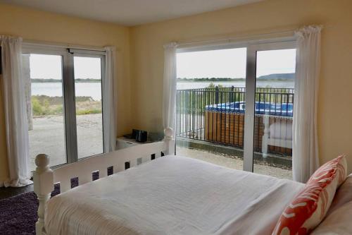 a bedroom with a bed and a view of the ocean at Waterfront 'Jemadda' Family Lodge in Bream Creek