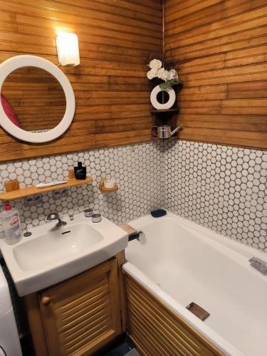 une salle de bain avec un lavabo, une baignoire et un miroir dans l'établissement Nid douillet, à Gréolières